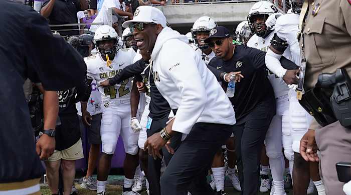 Colorado coach Deion Sanders runs onto the field with his team for a an NCAA college football game against TCU.